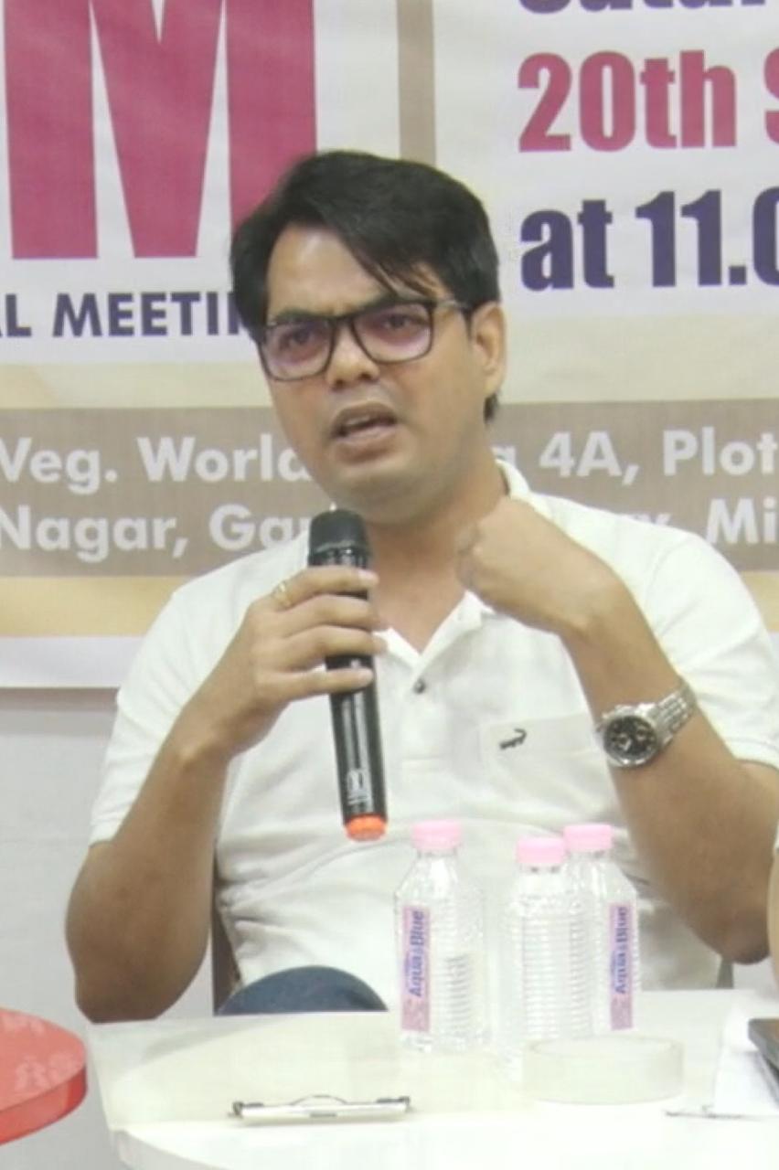 Consultant addressing a society general body meeting with a microphone